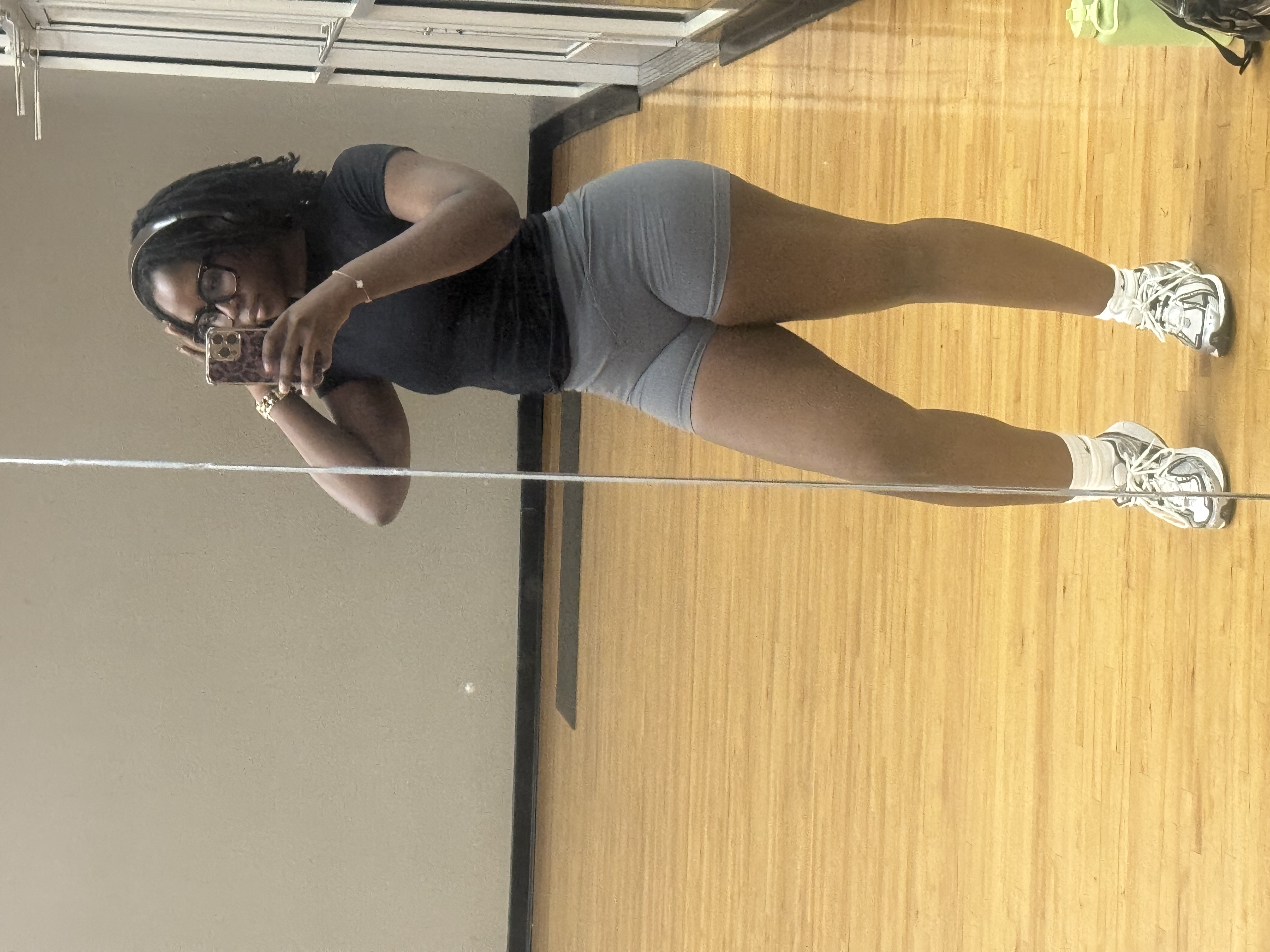 Gym mirror selfie showing a confident pose in activewear.
