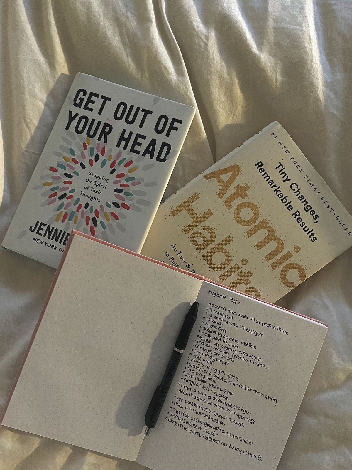 Open journal with a pen beside a warm cup of coffee on a cozy table.