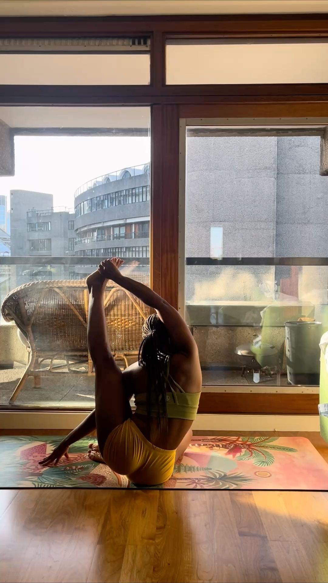 Person stretching on a yoga mat in a softly lit room.